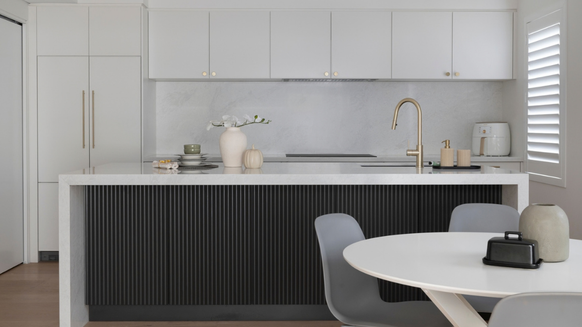Caesarstone Benchtops 4 Caesarstone Glacier Flow benchtop and matching splashback in a Scarborough kitchen with white overhead cabinets and a brass mixer tap