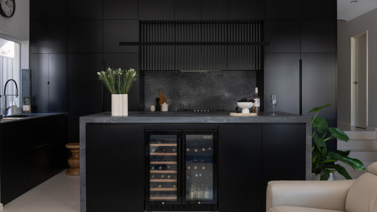 Caesarstone Benchtops 11 Caesarstone Rugged Concrete splashback and island benchtop below a fluted black rangehood panel in a Karrinyup kitchen