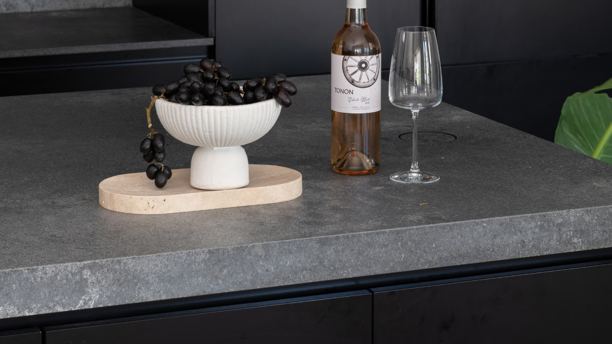 Caesarstone Benchtops 10 Close up of a Caesarstone Rugged Concrete island benchtop against matte black cabinetry in a Karrinyup kitchen
