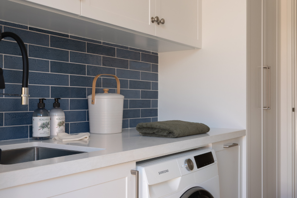 laundry renovation with blue subway tiles